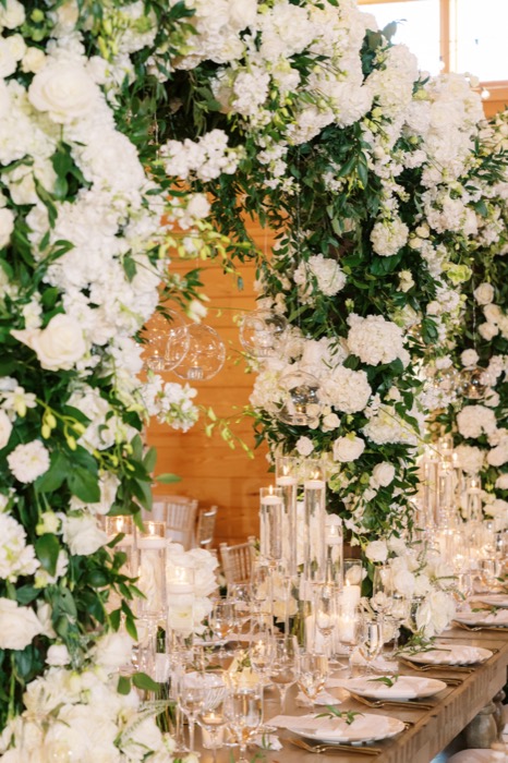 White floral arch framing a head table