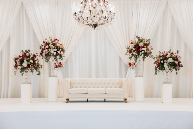 Cream tufted chesterfield sofa staged with florals